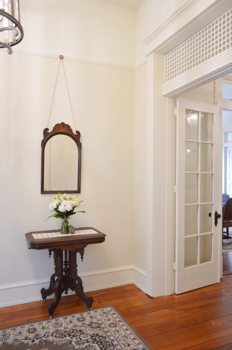 Entryway, foyer vintage antique table and mirror - Morgan Ford Southern Romance House in Mobile, Alabama - Renovation by Phantom Screens